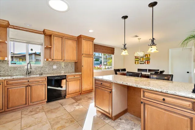 a kitchen with stainless steel appliances granite countertop a sink a stove and a wooden floor