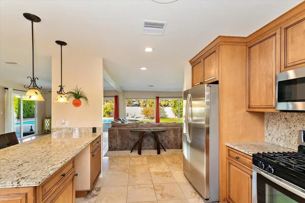 a kitchen with stainless steel appliances granite countertop a sink counter space cabinets and a stove
