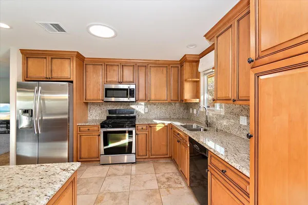 a kitchen with stainless steel appliances granite countertop a sink stove and refrigerator