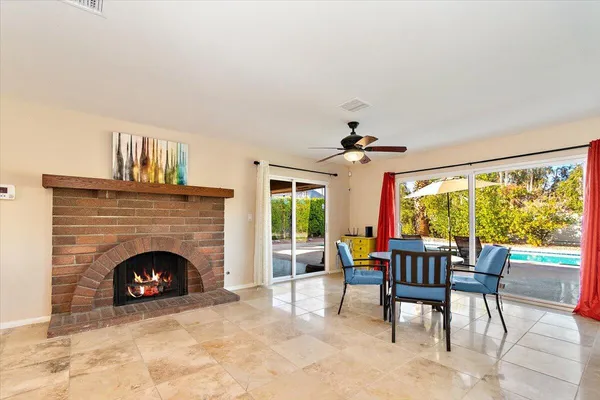a living room with furniture a fireplace and a floor to ceiling window