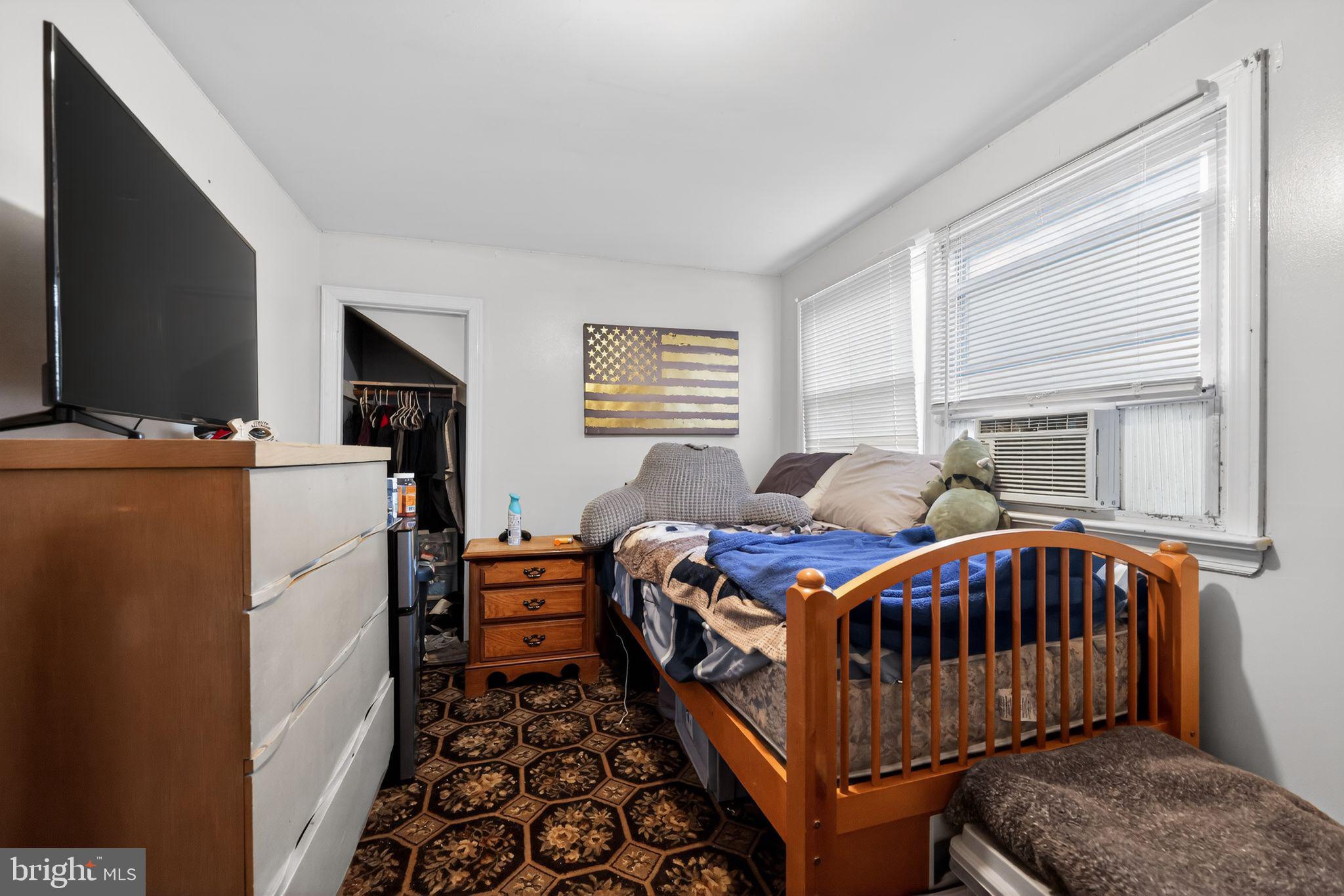 438 Ewingville Road Ewing, NJ 08638 - Photo 29 of 43 a bedroom with a bed and a baby crib with wooden floor