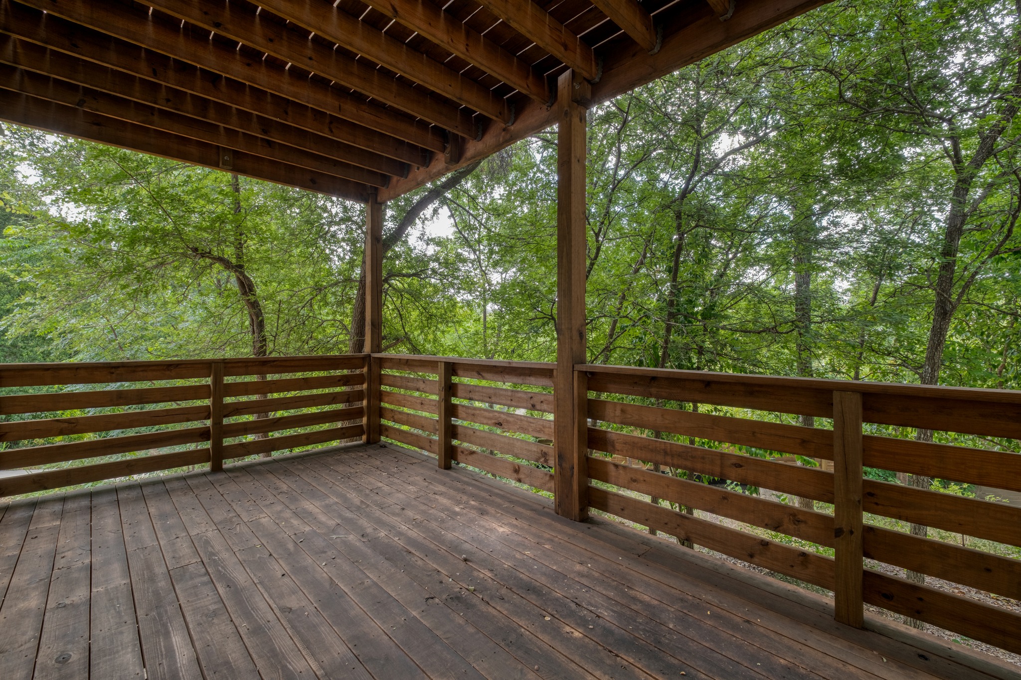 5211 Rob-Scott Street Austin, TX 78721 - Photo 24 of 24 An inviting deck extends into a lush, tree-filled landscape, creating a private outdoor retreat.