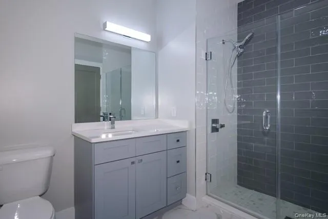 a bathroom with a granite countertop toilet a sink and a mirror