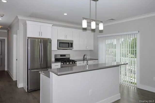 a kitchen with stainless steel appliances granite countertop a refrigerator a stove a sink and a center island