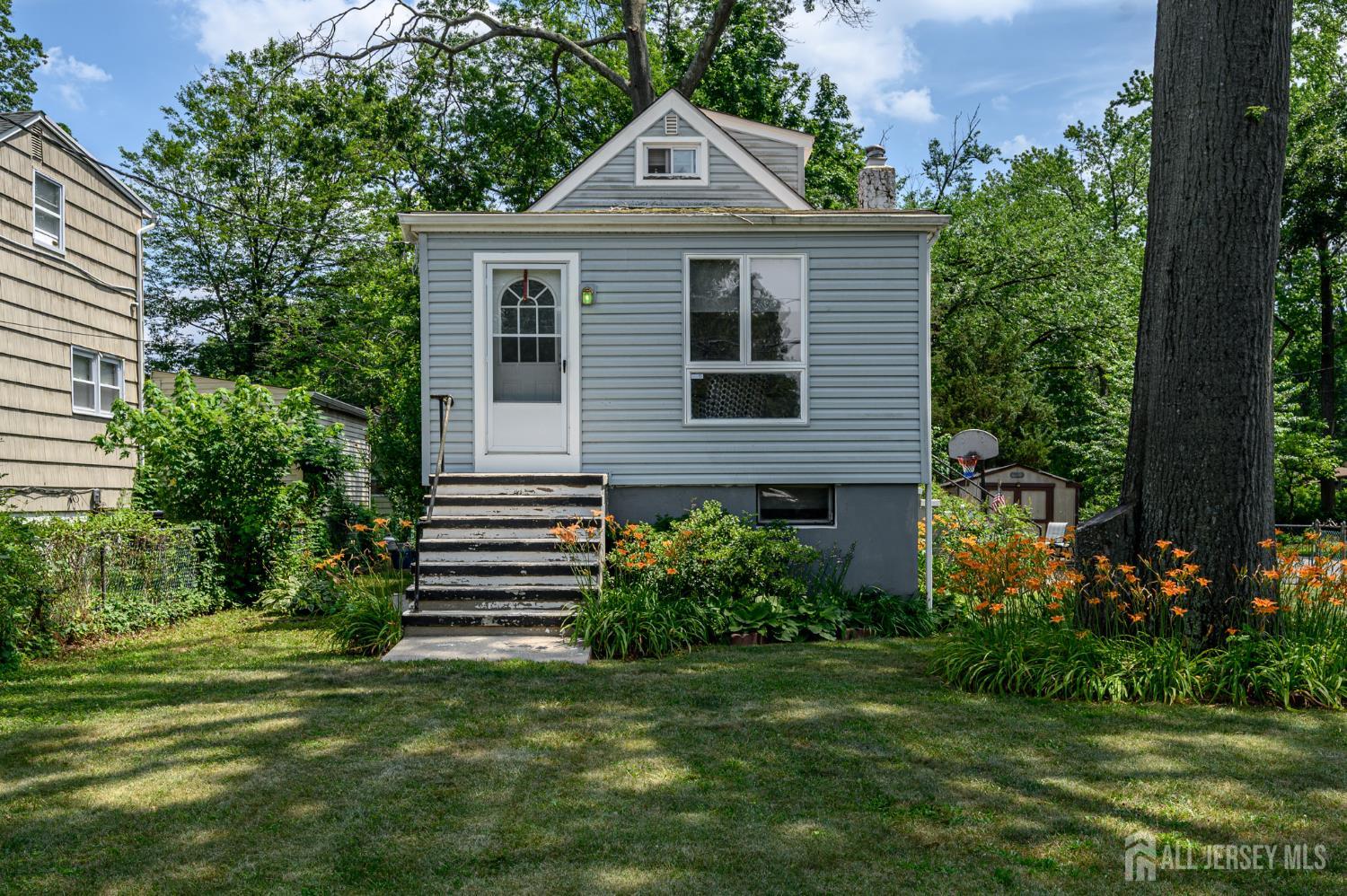 a front view of a house with a yard and trees