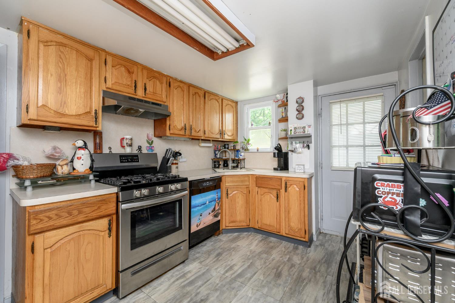 1650 Holly Road North Brunswick, NJ 08902 - Photo 11 of 41 a kitchen with stainless steel appliances a stove a sink dishwasher and cabinets with wooden floor