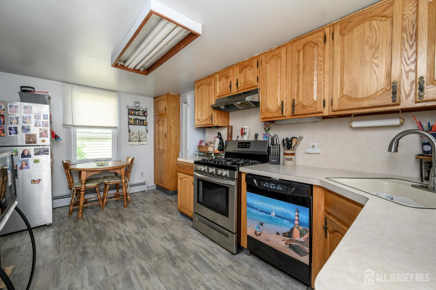 1650 Holly Road North Brunswick, NJ 08902 - Photo 13 of 41 a kitchen with stainless steel appliances granite countertop a stove a sink dishwasher and a refrigerator with wooden floor