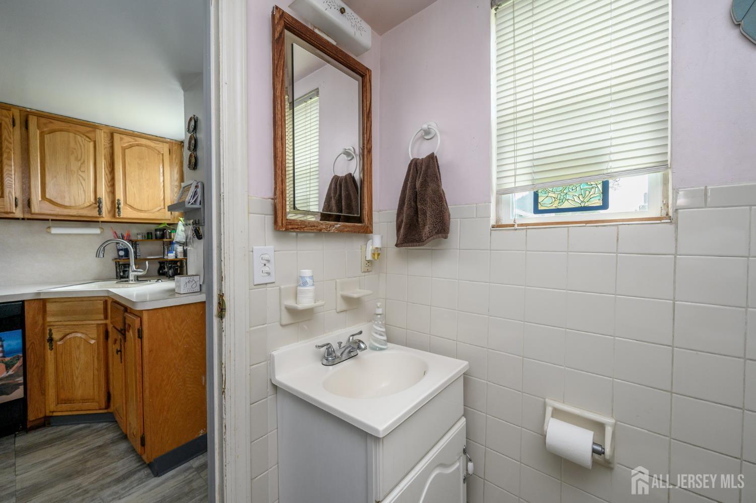 1650 Holly Road North Brunswick, NJ 08902 - Photo 16 of 41 a bathroom with a sink a vanity and a mirror