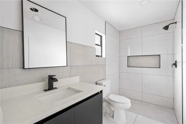 a bathroom with a sink a toilet and mirror