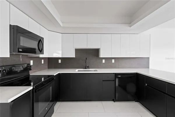 a kitchen with a sink a stove top oven and refrigerator