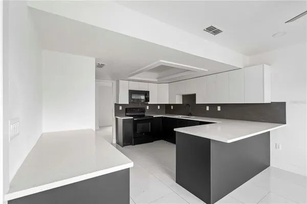 a kitchen with kitchen island a counter top space cabinets and stainless steel appliances