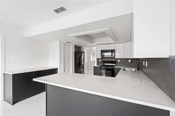 a kitchen with a sink appliances and cabinets