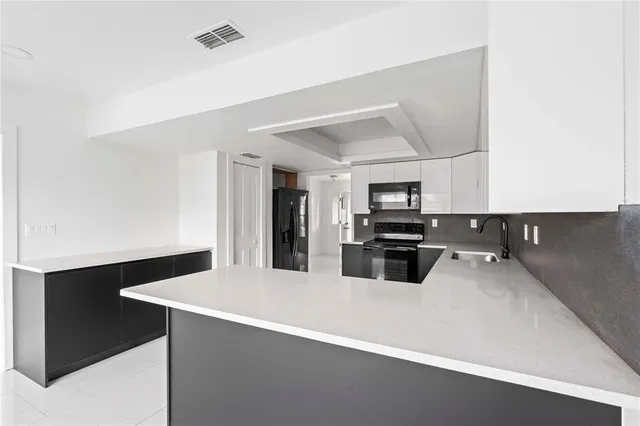 a kitchen with a sink appliances and cabinets