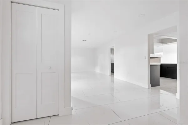 a view of a hallway to an empty room and fire place