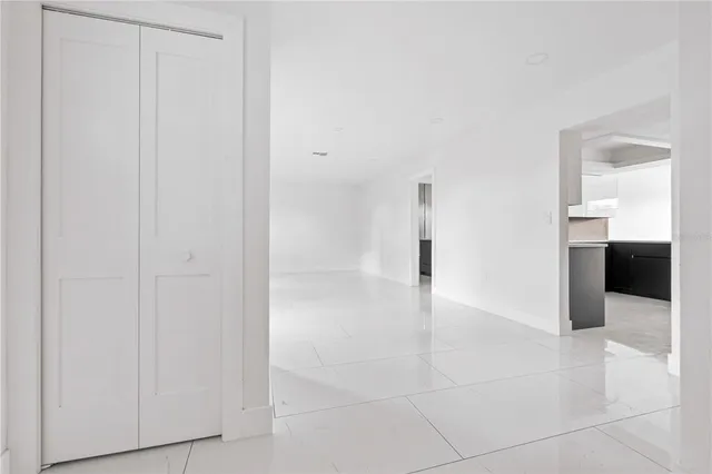 a view of a hallway to an empty room and fire place