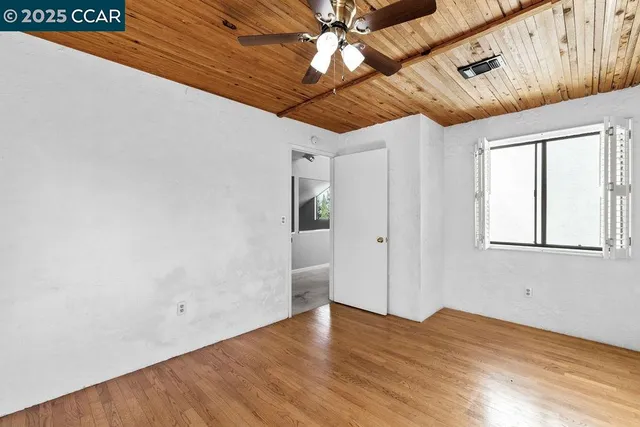 a view of empty room with wooden floor