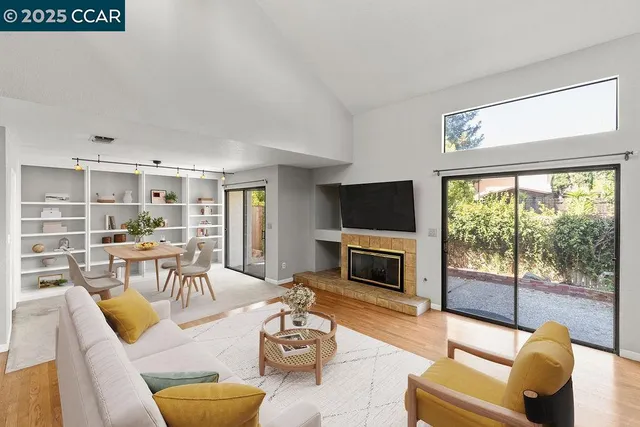 a living room with furniture fireplace and a large window