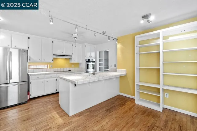 a kitchen with wooden floors and appliances