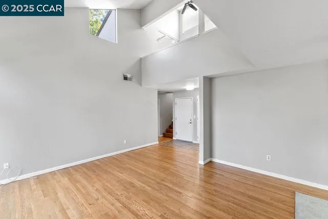 a view of an empty room with wooden floor