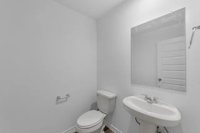 a bathroom with a sink a toilet and mirror
