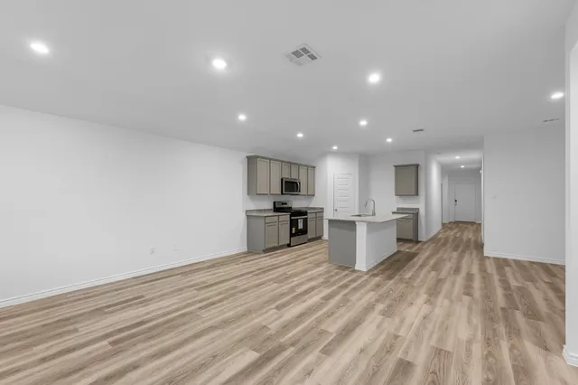 a view of kitchen with wooden floor and electronic appliances