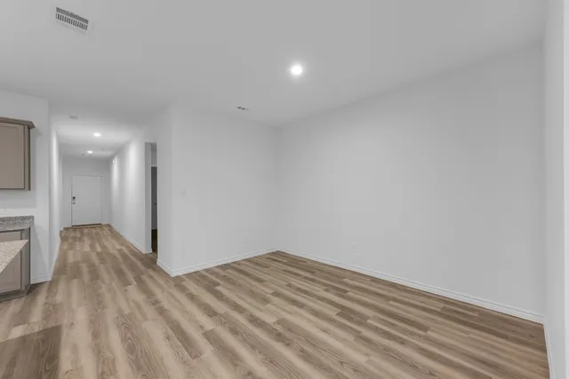 a view of empty room with wooden floor