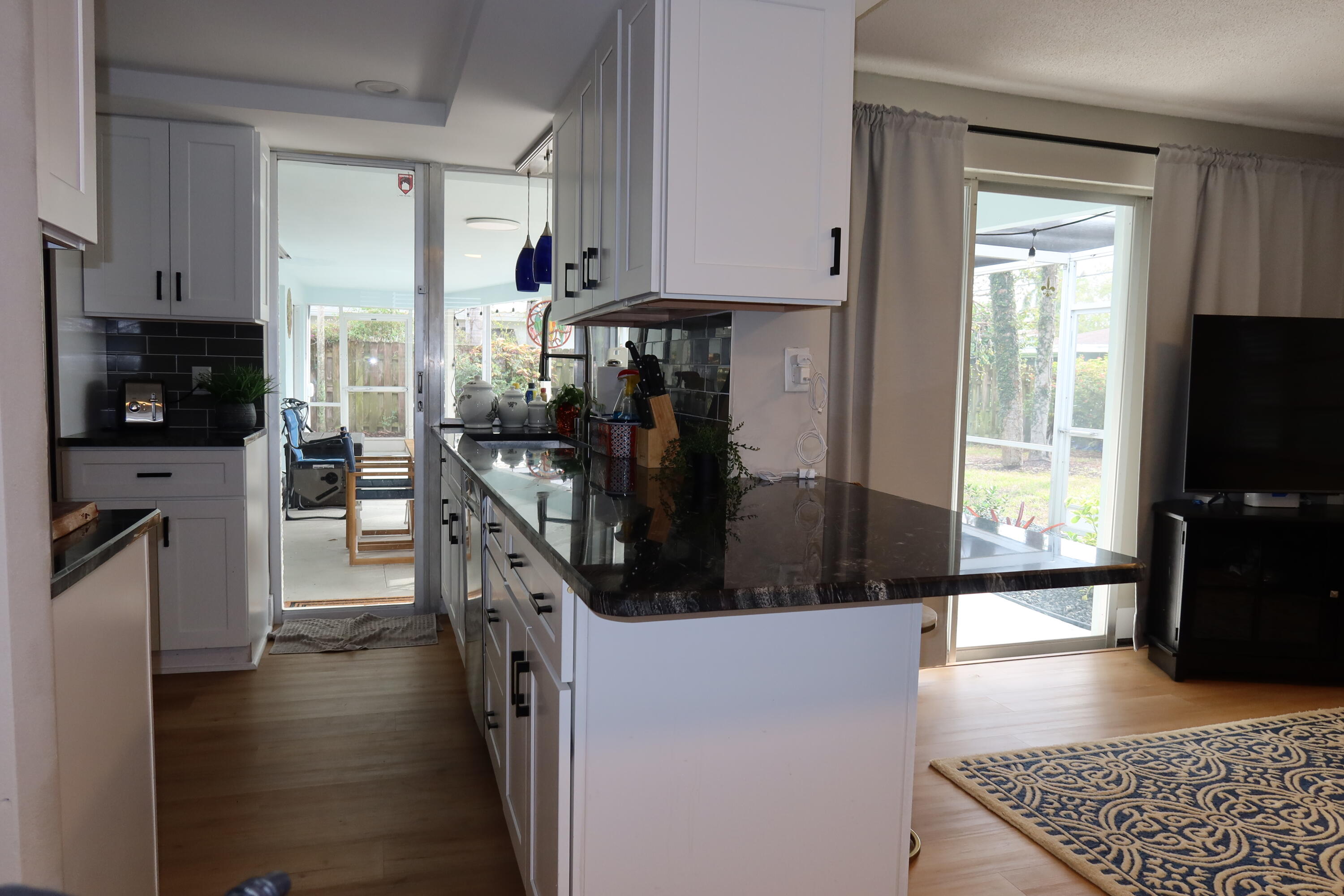1001 Southwest 12th Terrace Boca Raton, FL 33486 - Photo 3 of 13 a kitchen with stainless steel appliances kitchen island granite countertop a refrigerator a stove and a sink with wooden floor