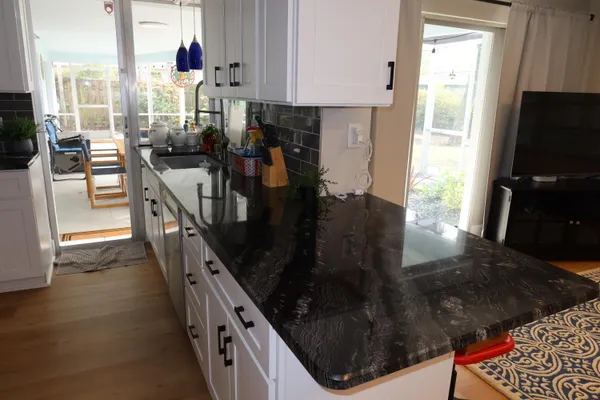 a kitchen with stainless steel appliances granite countertop a refrigerator a stove and a wooden floors