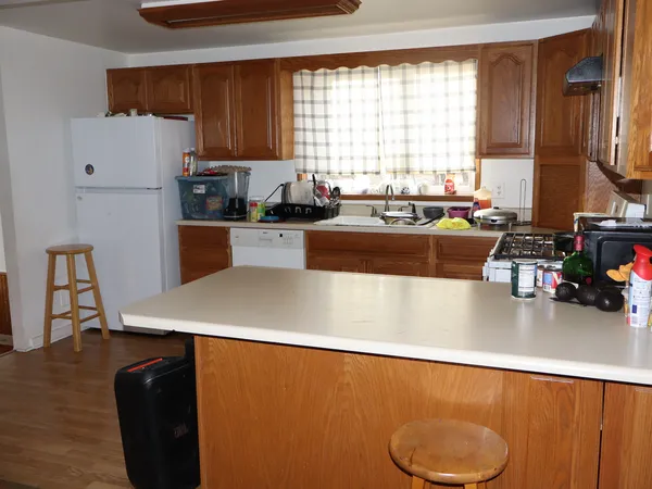 a kitchen with a refrigerator and a stove top oven
