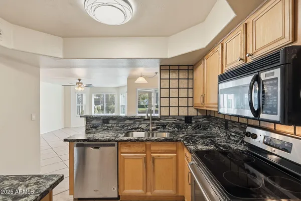 a kitchen with stainless steel appliances granite countertop a sink stove and cabinets
