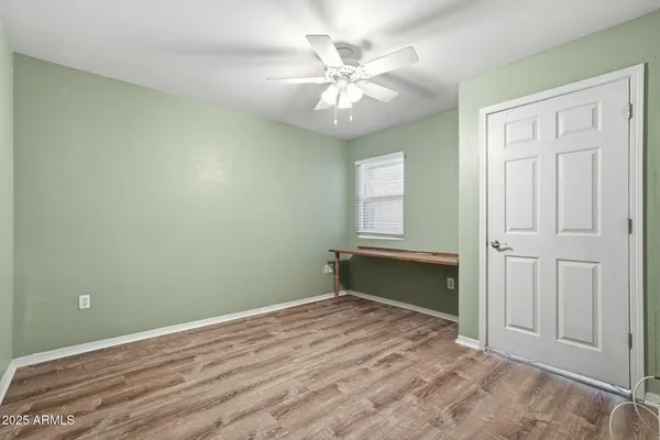 an empty room with a chandelier fan