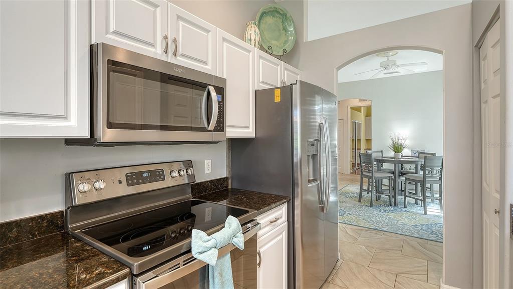 533 Fallbrook Drive Venice, FL 34292 - Photo 14 of 70 a kitchen with stainless steel appliances granite countertop a stove and a microwave