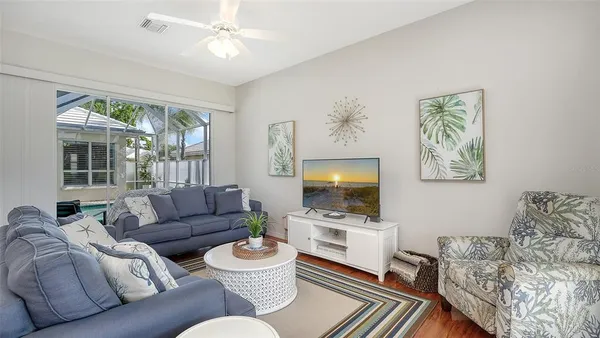 a view of a kitchen with kitchen island granite countertop a stove a oven a dining table and chairs with wooden floor