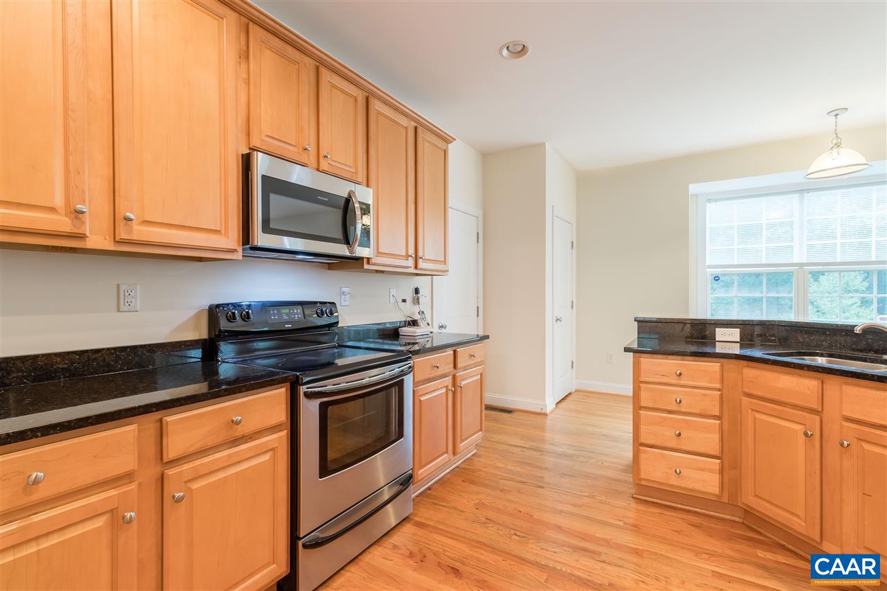 282 Lake Drive, Unit 2 Ruckersville, VA 22968 - Photo 5 of 27 a kitchen with granite countertop wooden cabinets stainless steel appliances and a window