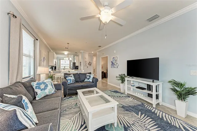 a living room with furniture a flat screen tv and a large window