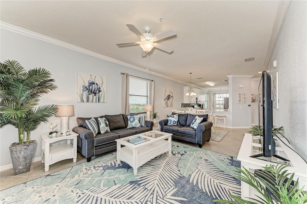16804 Vardon Terrace, Unit 308 Bradenton, FL 34211 - Photo 12 of 43 a living room with furniture and a chandelier