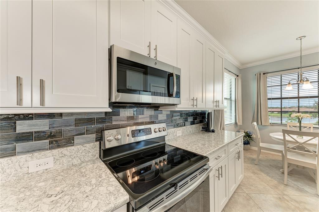 16804 Vardon Terrace, Unit 308 Bradenton, FL 34211 - Photo 16 of 43 a kitchen with stainless steel appliances a stove sink and microwave