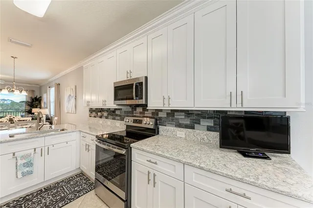 a kitchen with granite countertop white cabinets and white appliances