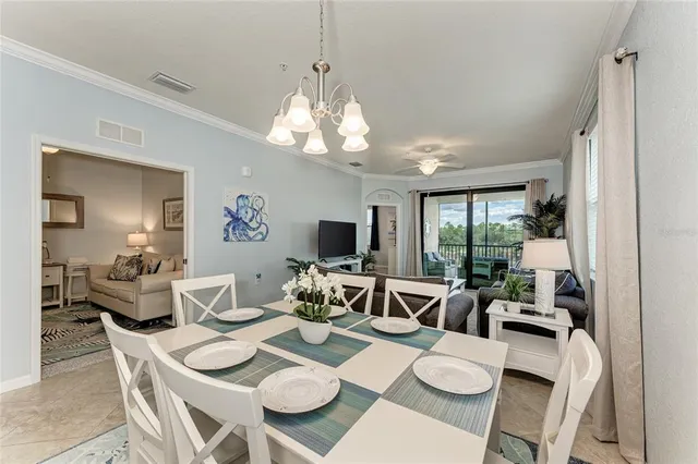 a view of a dining room with furniture a livingroom and chandelier