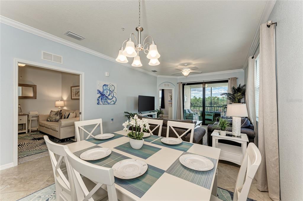 16804 Vardon Terrace, Unit 308 Bradenton, FL 34211 - Photo 8 of 43 a view of a dining room with furniture a livingroom and chandelier