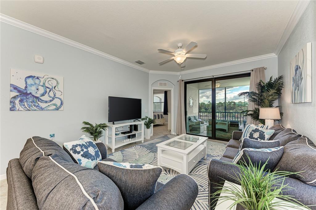 16804 Vardon Terrace, Unit 308 Bradenton, FL 34211 - Photo 10 of 43 a living room with furniture floor to ceiling window and a flat screen tv