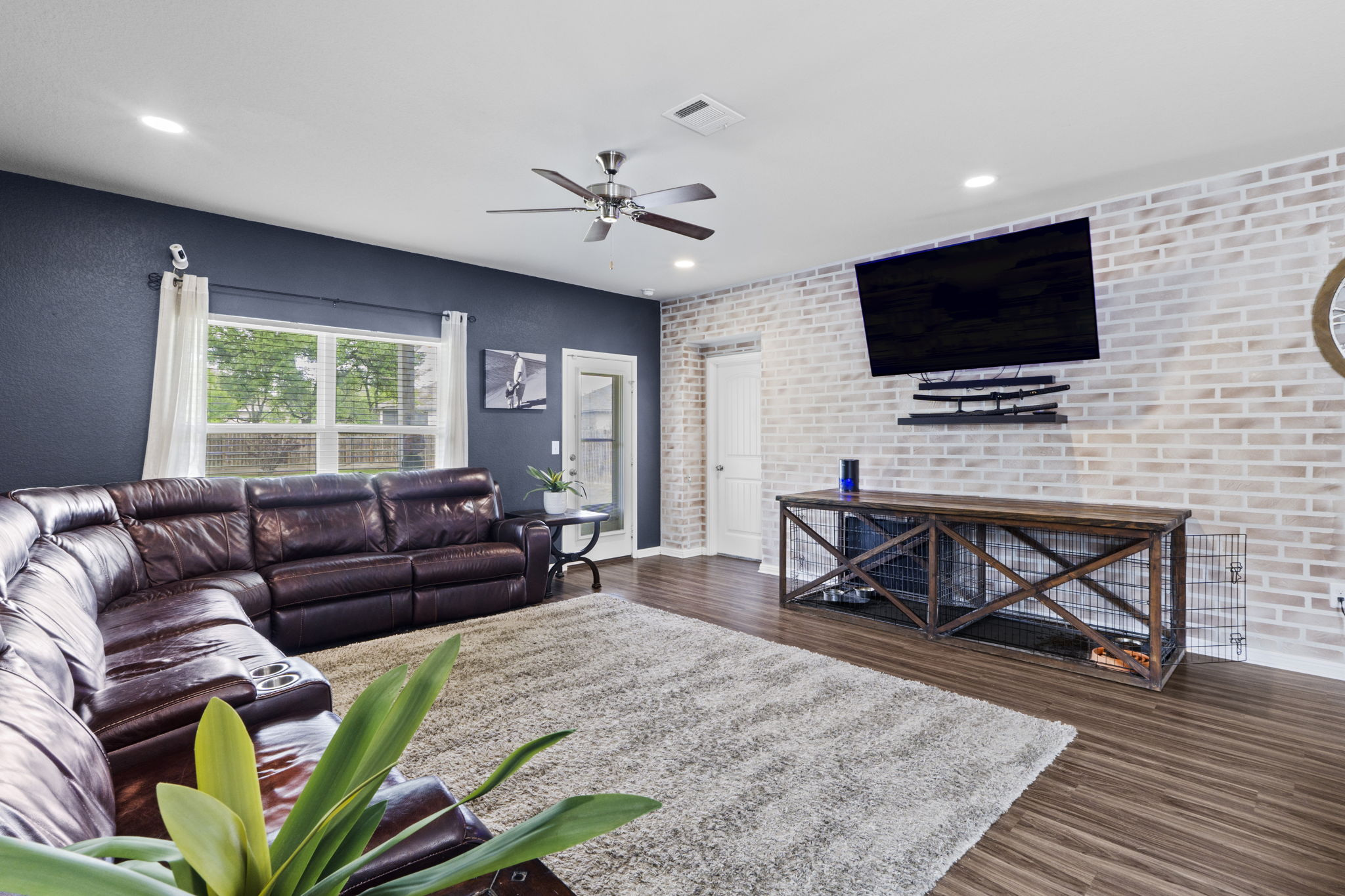 2417 Bridges Ranch Road Georgetown, TX 78628 - Photo 6 of 36 Living area featuring dark wood finished floors, brick wall, ceiling fan, and recessed lighting