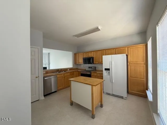 a kitchen with a refrigerator a stove top oven a sink and dishwasher