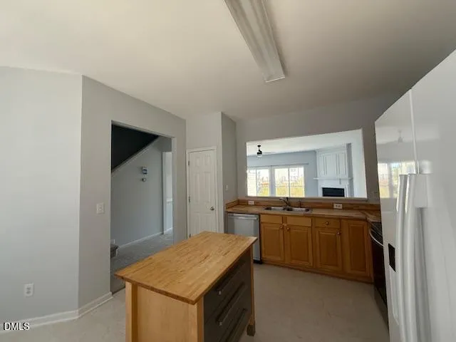 a kitchen with stainless steel appliances granite countertop a sink and a refrigerator
