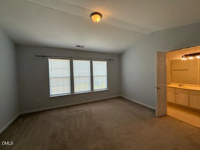 an empty room with cabinet and windows