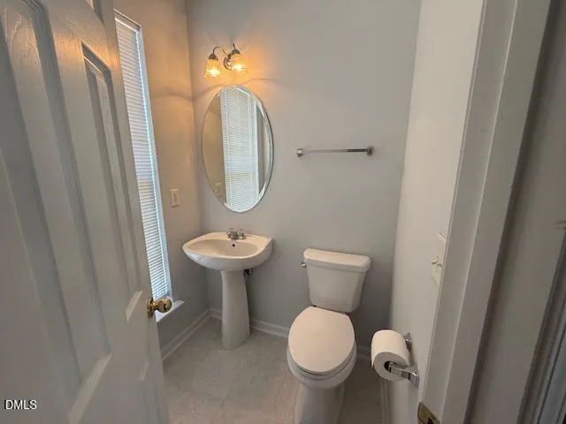 a bathroom with a sink toilet and a mirror