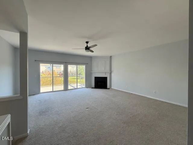 an empty room with windows and fireplace