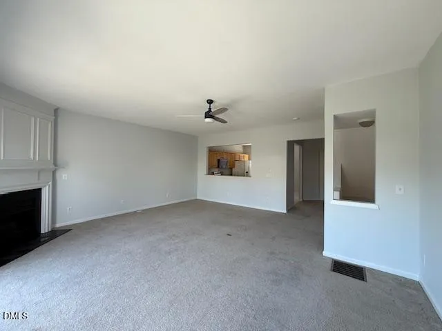 an empty room with fireplace and cabinet
