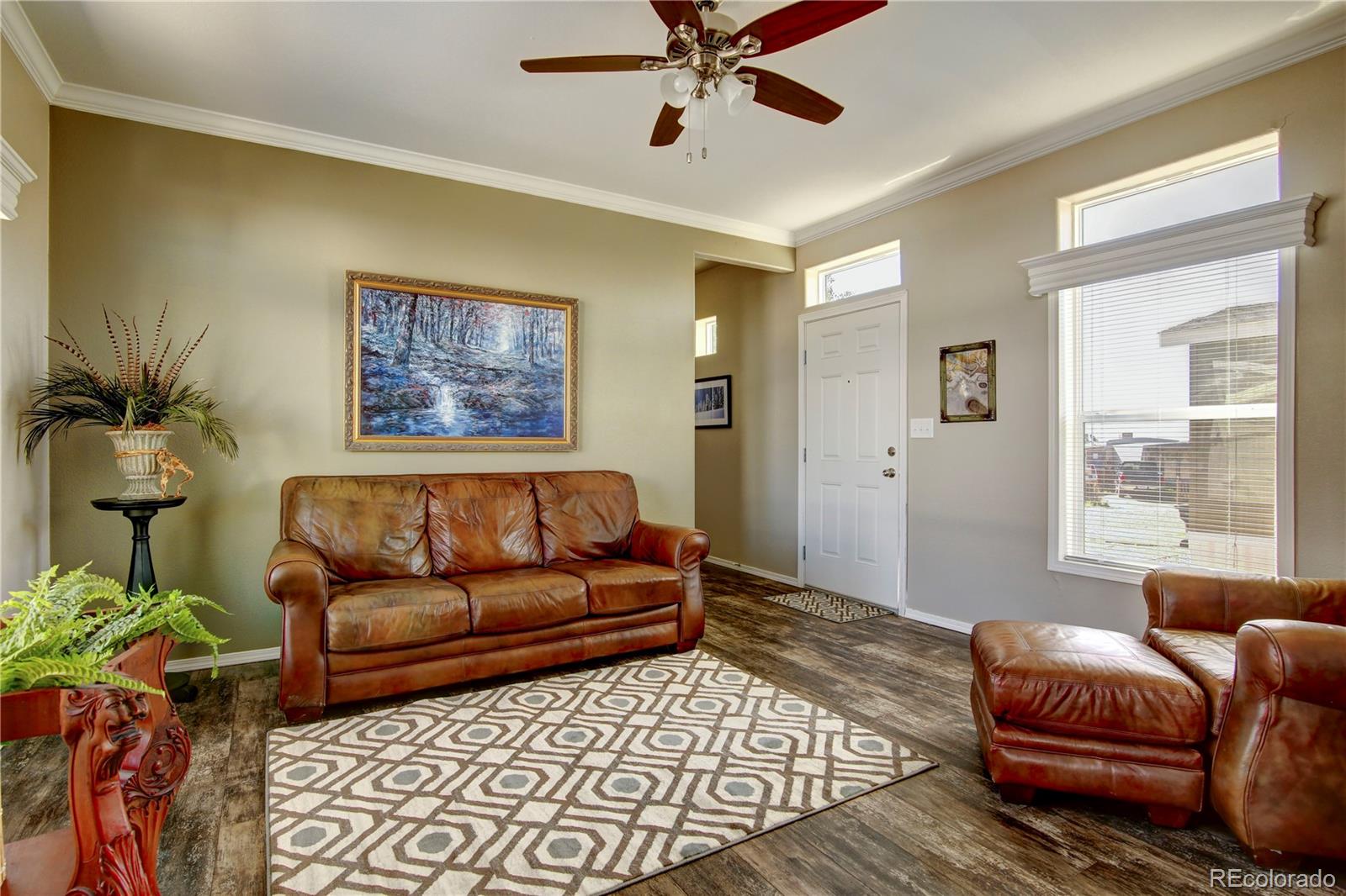 a living room with furniture ceiling fan and a rug