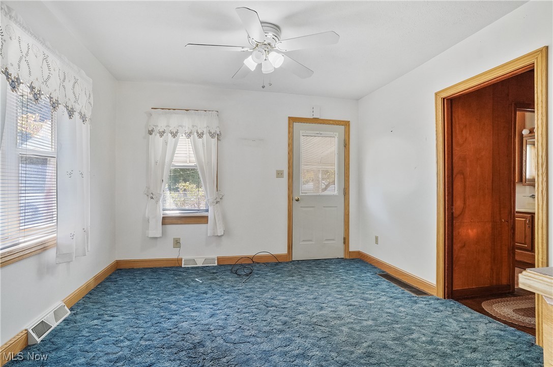 2809 McElwain Road Akron, OH 44312 - Photo 27 of 38 Carpeted dining room with ceiling fan, carpet, bay window on the side and front door.